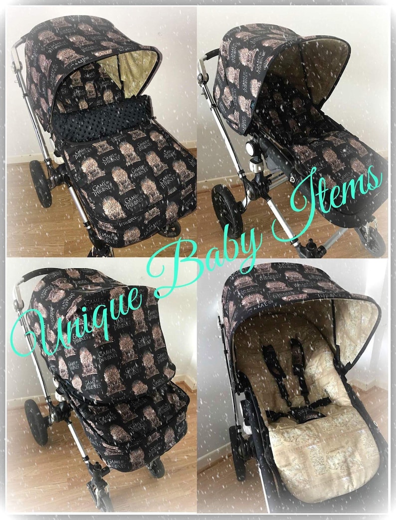 May include: A black stroller with a Game of Thrones themed fabric cover. The cover features a black and gold design with the words "Game of Thrones" and the Iron Throne. The stroller has a black and white polka dot liner and a black canopy.