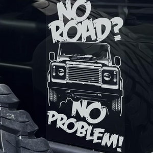 May include: Black and white graphic of a Land Rover Defender with the text "NO ROAD? NO PROBLEM!" on a black background. The image is mounted on a vehicle, with a tyre visible on the left.