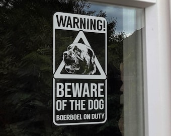 Peut inclure: Un panneau d'avertissement rectangulaire blanc et noir. Il affiche le texte "WARNING!" au-dessus d'une image triangulaire d'une tête de chien. En dessous, on peut lire "BEWARE OF THE DOG" et "BOERBOEL ON DUTY".