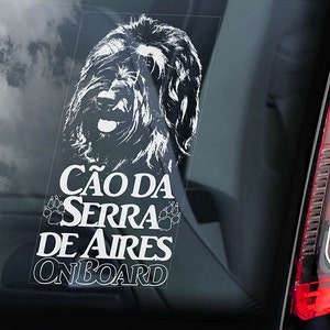 May include: White vinyl car sticker with a black and white illustration of a dog breed called "Cão da Serra de Aires" with the text "Onboard" below the image.
