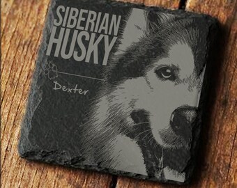 Può includere: Un sottobicchiere quadrato in ardesia grigio scuro con un'illustrazione dettagliata di un cane Husky siberiano. Il testo "SIBERIAN HUSKY" è stampato in alto, con il nome "Dexter" sotto. Il sottobicchiere è posto su uno sfondo di legno.