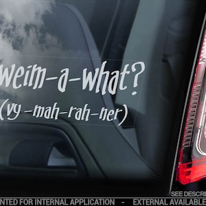 Op de afbeelding: Een witte vinyl sticker met de tekst "Weim-a-what? (vy-mah-rah-ner)" op een zwart autovenster.