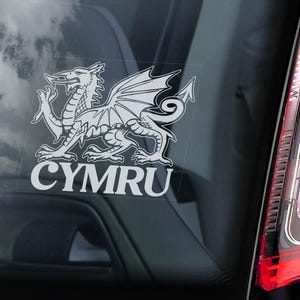 Könnte beinhalten: Ein weißer Vinyl-Aufkleber mit einem Schwarzweißbild des walisischen Drachen und dem Wort "CYMRU" darunter.