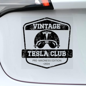 Puede incluir: Una pegatina en blanco y negro con un logotipo vintage de Tesla Club. El logotipo presenta un casco con un logotipo de Tesla y el texto "Vintage Tesla Club Pre-Madness Edition <2024".