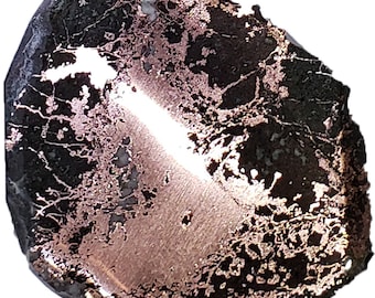May include: A polished stone with a dark, almost black base color, overlaid with intricate copper-colored patterns. The stone has a smooth, reflective surface with areas of lighter, almost white, inclusions. The overall shape is irregular and organic.
