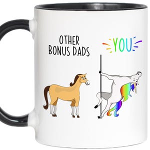 May include: White ceramic mug with a black handle and rim. The mug features the text "OTHER BONUS DADS" and "YOU" with a cartoon horse and a unicorn. The unicorn is pole dancing.