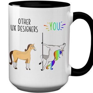May include: White ceramic mug with a black interior and handle. The mug features a humorous design with the text "OTHER UX DESIGNERS" and "YOU". The illustration shows a horse and a unicorn on a pole. The unicorn has a rainbow mane and tail.