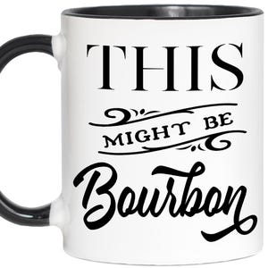 Puede incluir: Taza de cer&aacute;mica blanca con asa y borde negros. La taza presenta el texto "THIS MIGHT BE Bourbon" en negro, con letras estilizadas. Una l&iacute;nea decorativa separa las palabras.
