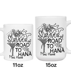 K&ouml;nnte beinhalten: Zwei wei&szlig;e Keramikbecher mit schwarzem Text und Illustrationen. Der Text lautet "Survivor of Road to Hana" mit Details &uuml;ber die Stra&szlig;e. Ein Becher ist 312 ml, der andere 425 ml. Das Design umfasst Berge und eine Palme.