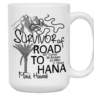 K&ouml;nnte beinhalten: Wei&szlig;e Keramiktasse mit schwarzem Grafikdesign. Das Design enth&auml;lt den Text "Survivor of Road to Hana" mit Details zu Kurven, Br&uuml;cken und Entfernung der Stra&szlig;e. Ein Berg und eine Palme sind ebenfalls abgebildet.