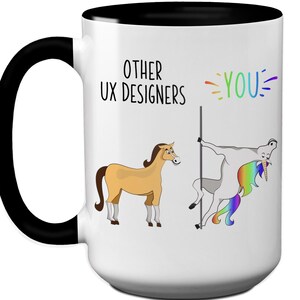 May include: White ceramic mug with a black handle and interior. The mug features a humorous design with the text "OTHER UX DESIGNERS" and "YOU" with a cartoon horse and unicorn. The unicorn has a rainbow mane and tail.