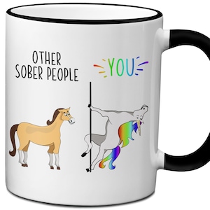 May include: White ceramic mug with a black handle. The mug has a cartoon image of a horse and a unicorn. The text on the mug reads "Other Sober People" and "You".