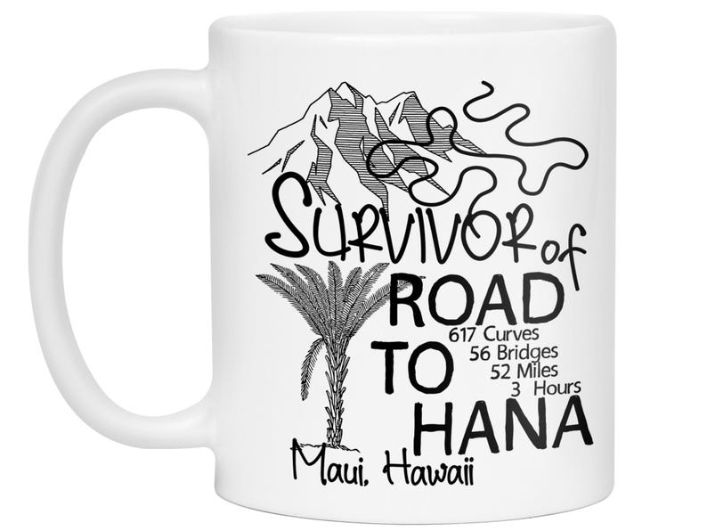 K&ouml;nnte beinhalten: Wei&szlig;e Keramik-Tasse mit schwarzem Grafikdesign. Das Design umfasst einen Berg, eine Palme und den Text "Survivor of Road to Hana" mit Angaben zu Kilometerstand und Zeit. "Maui, Hawaii" ist ebenfalls aufgedruckt.