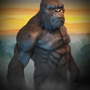 May include: A close-up of a large, muscular gorilla statue with a serious expression. The statue is made of a dark grey material and has a realistic texture. The gorilla is standing in front of a blurred background of a sunset and jungle.