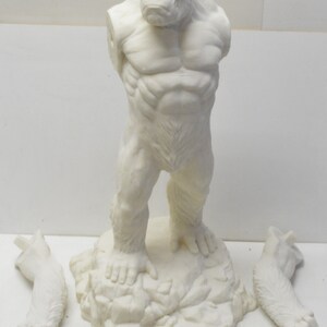 May include: An unpainted, plastic model kit of a gorilla standing on a rocky base. The model is in pieces, with two arms detached.