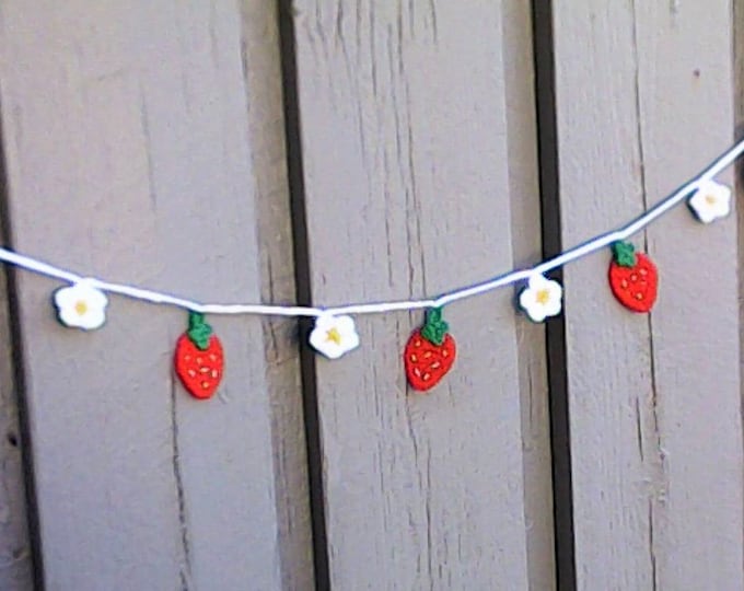 Crocheted mini garland with strawberries and small white flowers