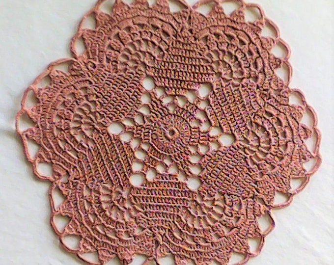 Round crocheted ornamental cover in pink cotton