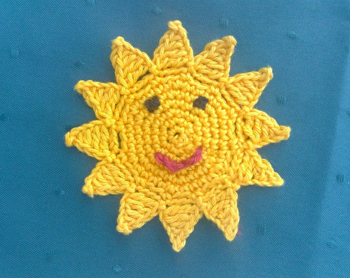 Crocheted sun with a funny face for children's birthday party decoration