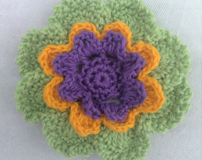 Larger crocheted flower in three colors in green, yellow and purple