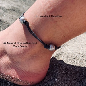Puede incluir: Un brazalete de tobillo de cordón de cuero gris con tres perlas grises. El brazalete está puesto en el tobillo de una persona. El texto "#9 Natural Blue leather cord Gray Pearls" es visible en la imagen.