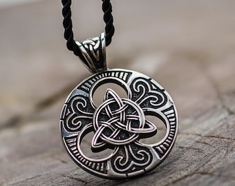 May include: A silver Celtic knot pendant necklace with a black cord. The pendant features a circular design with intricate knotwork.
