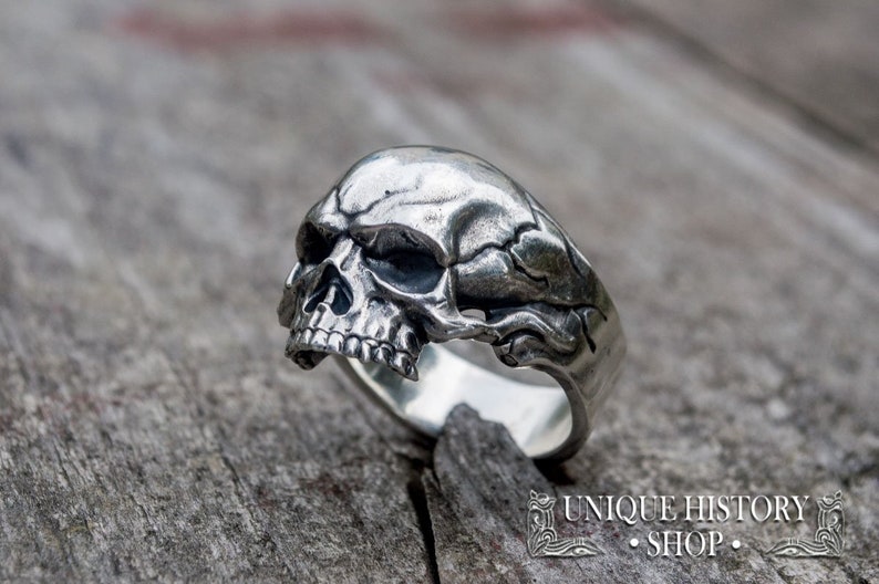 Pu&ograve; includere: Un anello d'argento a forma di teschio con dettagli intricati. Il teschio &egrave; di profilo e presenta una mascella e delle orbite dettagliate.