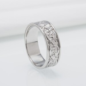 May include: A silver ring with a Celtic knot design.