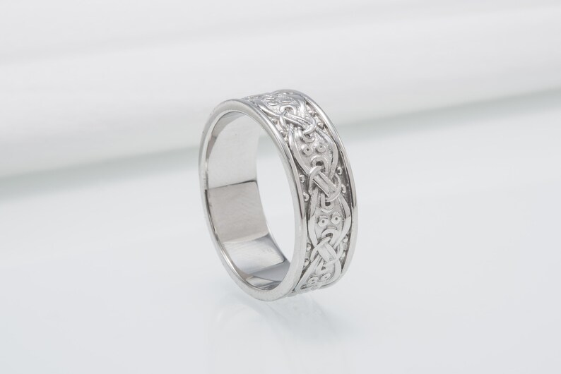 May include: A silver ring with a Celtic knot design.
