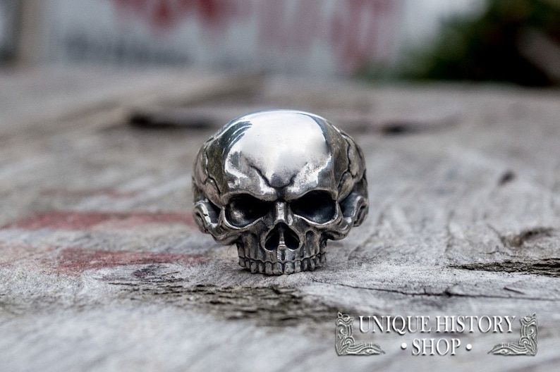 Pu&ograve; includere: Un anello in argento a forma di teschio con dettagli intricati. Il teschio &egrave; raffigurato con una fronte prominente e una mascella dettagliata.