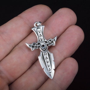May include: Silver pendant in the shape of a sword with the word "Valhalla" inscribed on it.