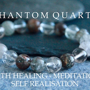 Könnte beinhalten: Ein Armband aus klaren Quarzkugeln mit Phantomeinschlüssen. Die Kugeln sind eine Mischung aus klar, weiß und braun. Das Armband liegt auf einem blauen Hintergrund mit dem Text "PHANTOM QUARTZ EARTH HEALING - MEDITATION - SELF REALISATION".