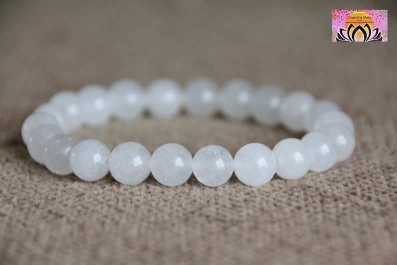 May include: White gemstone bracelet with round beads. The bracelet is made of natural white stones and is a simple and elegant design.