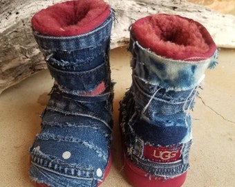 May include: A pair of red and blue denim boots with white polka dots. The boots have a red lining and the brand name "UGG Australia" is visible on one boot.