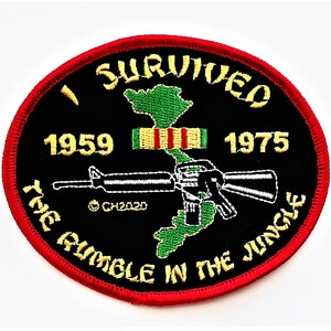 May include: A black and red embroidered patch with a green outline of Vietnam, a rifle, and the text "I Survived The Rumble In The Jungle 1959 - 1975".