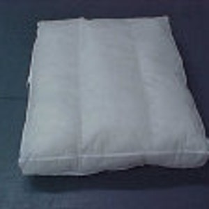 May include: A white, rectangular pillow filled with a soft, fluffy material. The pillow is made of a smooth, white fabric and has a simple, clean design.