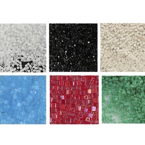 May include: Assortment of square seed beads in six colors: white, black, cream, light blue, red, and green.