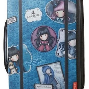 May include: A blue zipped binder featuring a damask pattern and multiple illustrations of characters with long hair. The cover includes the text Santoro London, By Air Mail, and My Stamp Collection, along with black vertical straps and a side handle.