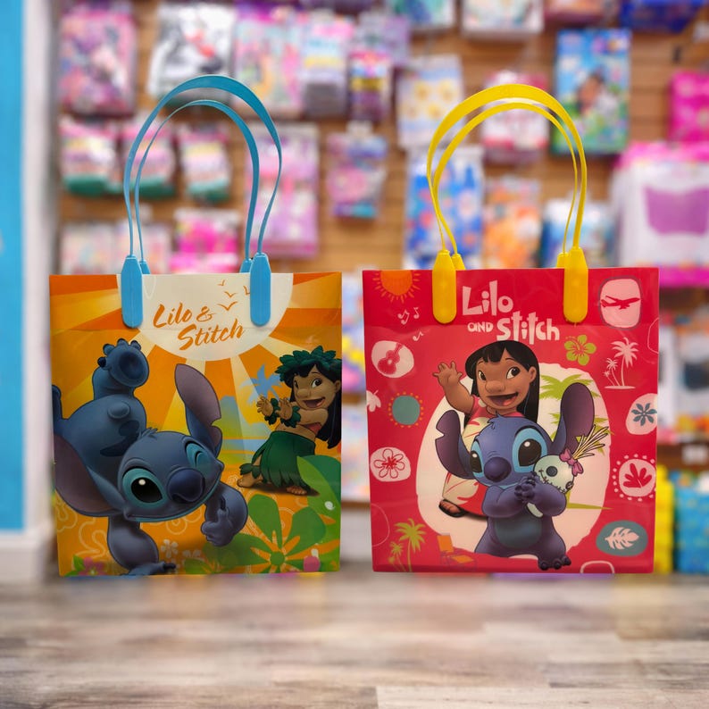 May include: Two rectangular gift bags featuring Lilo & Stitch. The left bag is yellow and orange with Stitch and Lilo, and blue handles. The right bag is red with Lilo and Stitch holding a doll, and yellow handles. Both bags display the text Lilo & Stitch.