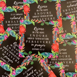 May include: A set of inspirational cards with a tropical floral design. The cards feature the text "Rejoice in the hope, endure under tribulation, persevere in prayer" with a scripture reference from Romans 12:12.