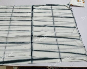 May include: White fabric with a grid pattern of dark blue tie-dye. The fabric is folded in half and laid flat on a white surface.