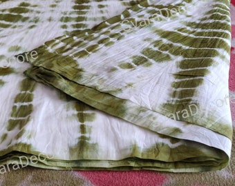 Puede incluir: Una tela de color blanco y verde con un borde doblado. La tela tiene un patrón de color verde claro y blanco.