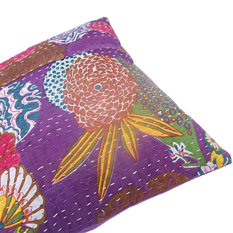 May include: Purple cotton pillow cover with a colorful floral pattern. The pattern features a large flower with yellow petals and a red center, surrounded by smaller flowers and swirls.