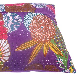 May include: Purple cotton pillow cover with a floral pattern in shades of pink, red, green, yellow, and white. The pillow cover is quilted with a white thread.