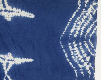 May include: A blue fabric with a white tie-dye pattern. The fabric has a wrinkled texture.