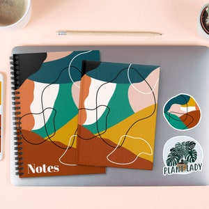 Pu&ograve; includere: Due quaderni a spirale con disegni geometrici astratti in tonalit&agrave; di marrone, giallo, verde e bianco. I quaderni hanno la scritta "Notes" stampata sulla copertina. I quaderni sono su un laptop con due adesivi, uno con un disegno di una pianta e il testo "Plant Lady" e l'altro con un design astratto simile.