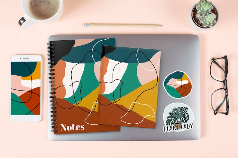 Pu&ograve; includere: Due quaderni a spirale con disegni geometrici astratti in tonalit&agrave; di marrone, giallo, verde e bianco. I quaderni hanno la scritta "Notes" stampata sulla copertina. I quaderni sono su un laptop con due adesivi, uno con un disegno di una pianta e il testo "Plant Lady" e l'altro con un design astratto simile.