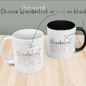 May include: Two white coffee mugs with black handles. One mug has the word "Wanderlust" in black lettering and the other mug has the word "Wanderlust" in rust colored lettering. Both mugs have the definition of wanderlust printed below the word.