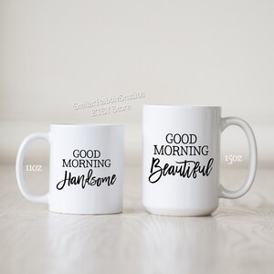 Peut inclure: Deux tasses en c&eacute;ramique blanche avec du texte noir. La tasse la plus petite est de 11 oz et dit "Good Morning Handsome". La tasse la plus grande est de 15 oz et dit "Good Morning Beautiful".