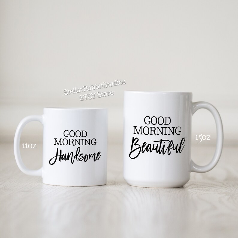 Peut inclure: Deux tasses en c&eacute;ramique blanche avec du texte noir. La tasse la plus petite est de 11 oz et dit "Good Morning Handsome". La tasse la plus grande est de 15 oz et dit "Good Morning Beautiful".
