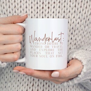 May include: White ceramic mug with a brown inscription that reads "Wanderlust: A strong desire to wander or travel and explore the places that set your soul on fire."